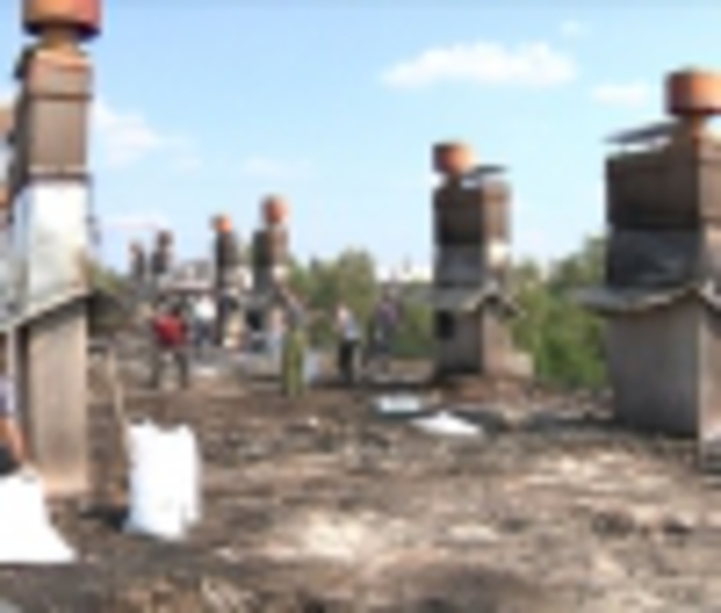 80 persons pull down blockages on a roof of the burned house